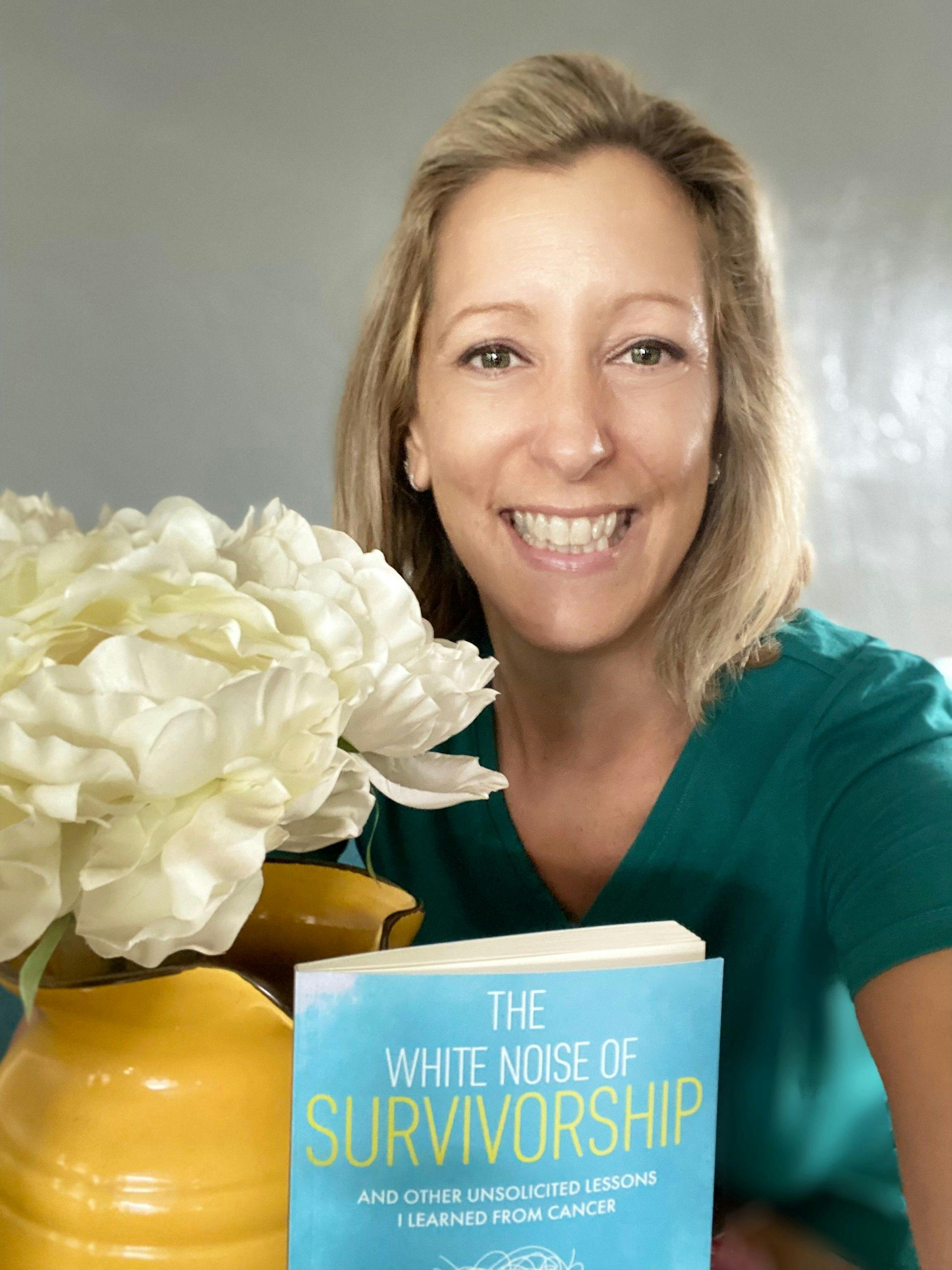 Cancer survivor Tara Rolle holding a copy of her book, The White Noise of Survivorship: and Other Unsolicited Lessons I Learned From Cancer.”