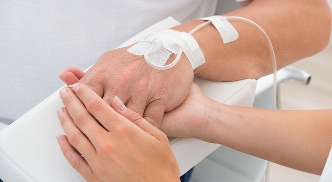oncology nurse holding a patient's hand