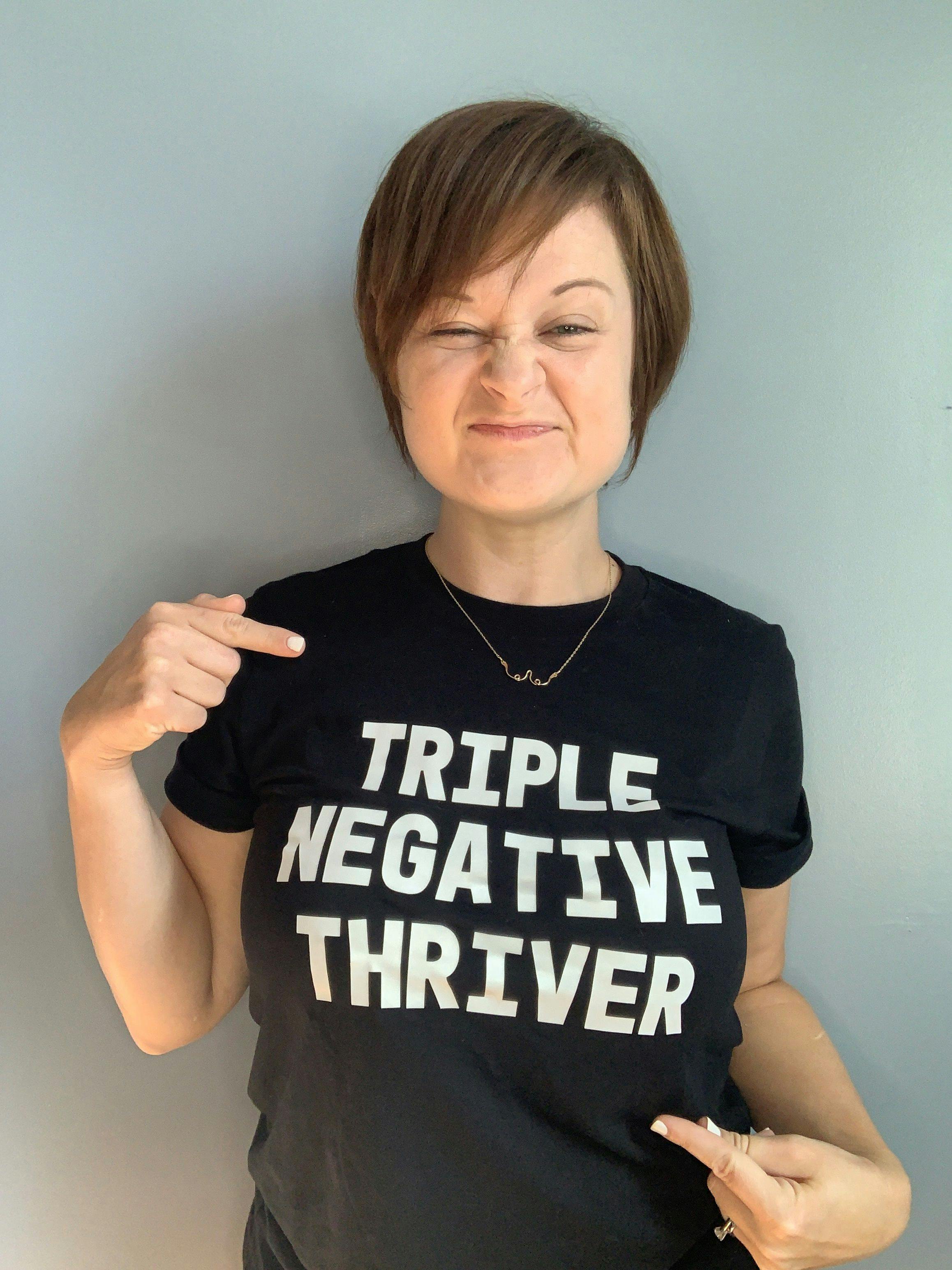 TNBC survivor Kelly Thomas wearing a black shirt that says, "TRIPLE NEGATIVE THRIVER"