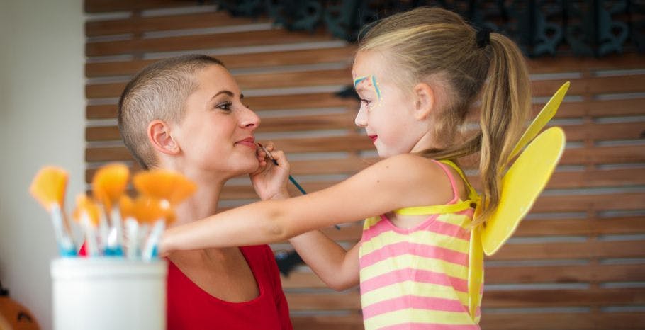 child painting her cancer patient mother's lips