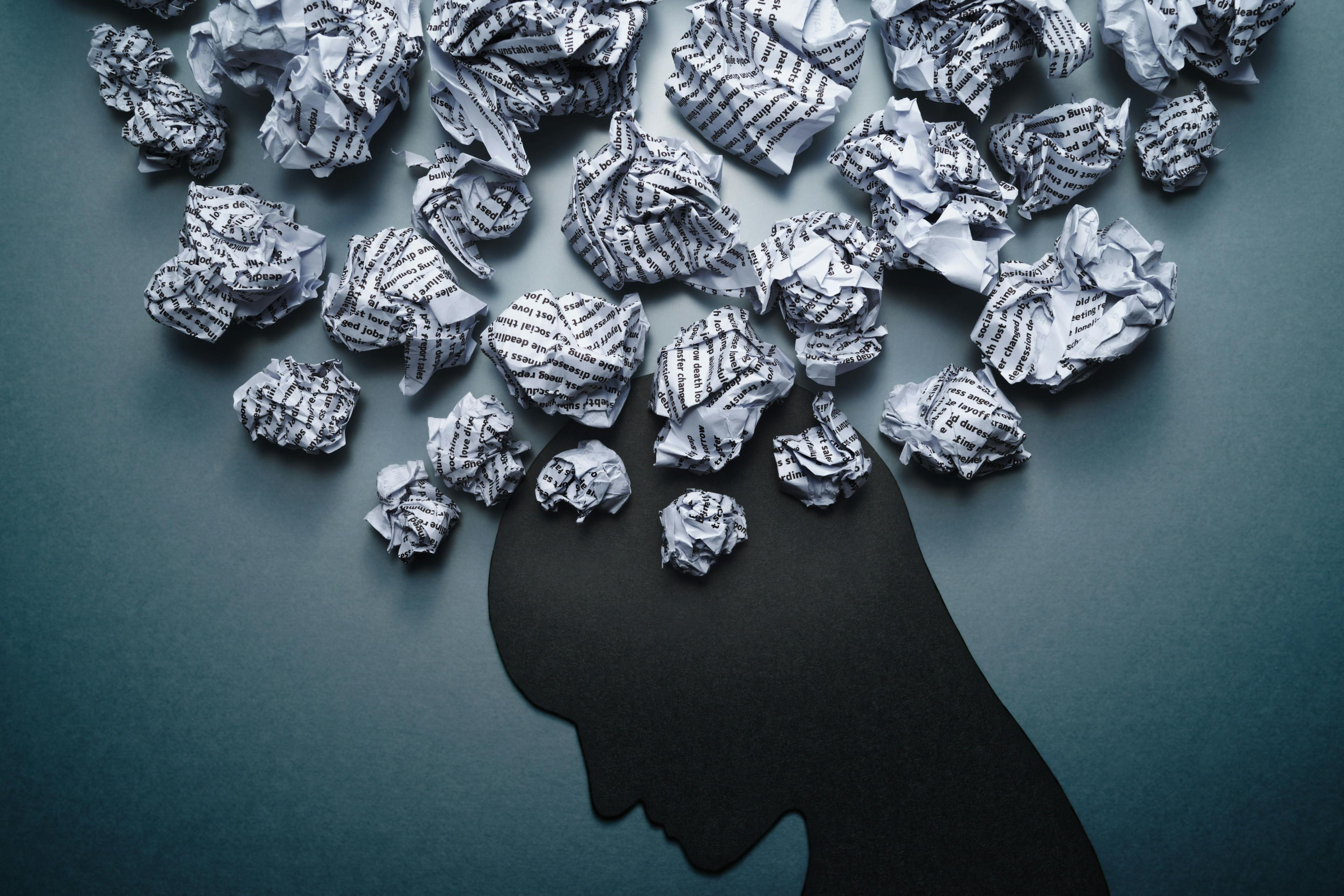 Silhouette of depressed person head. Concept image of depression and anxiety. Waste paper and head silhouette. | Image credit: © tadamichi - stock.adobe.com