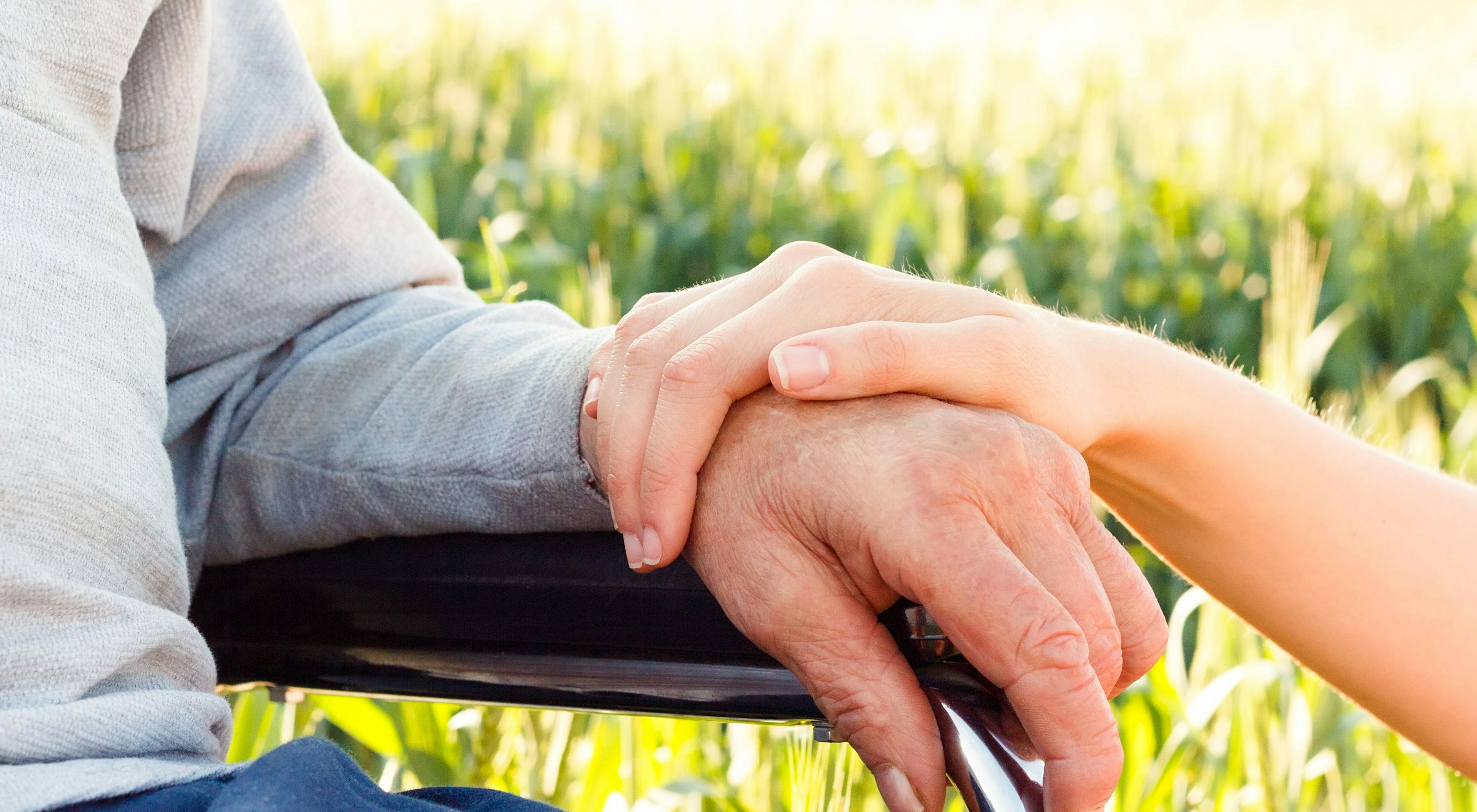 caregiver placing their hand on top of their loved one's
