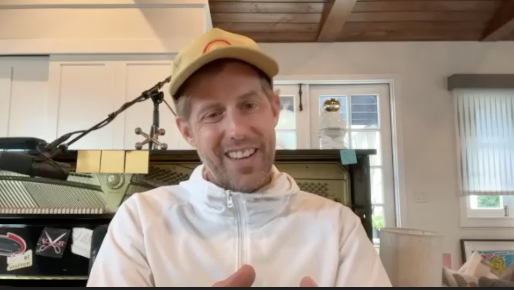 Andrew McMahon, wearing a white sweater and a hat, in an interview with CURE