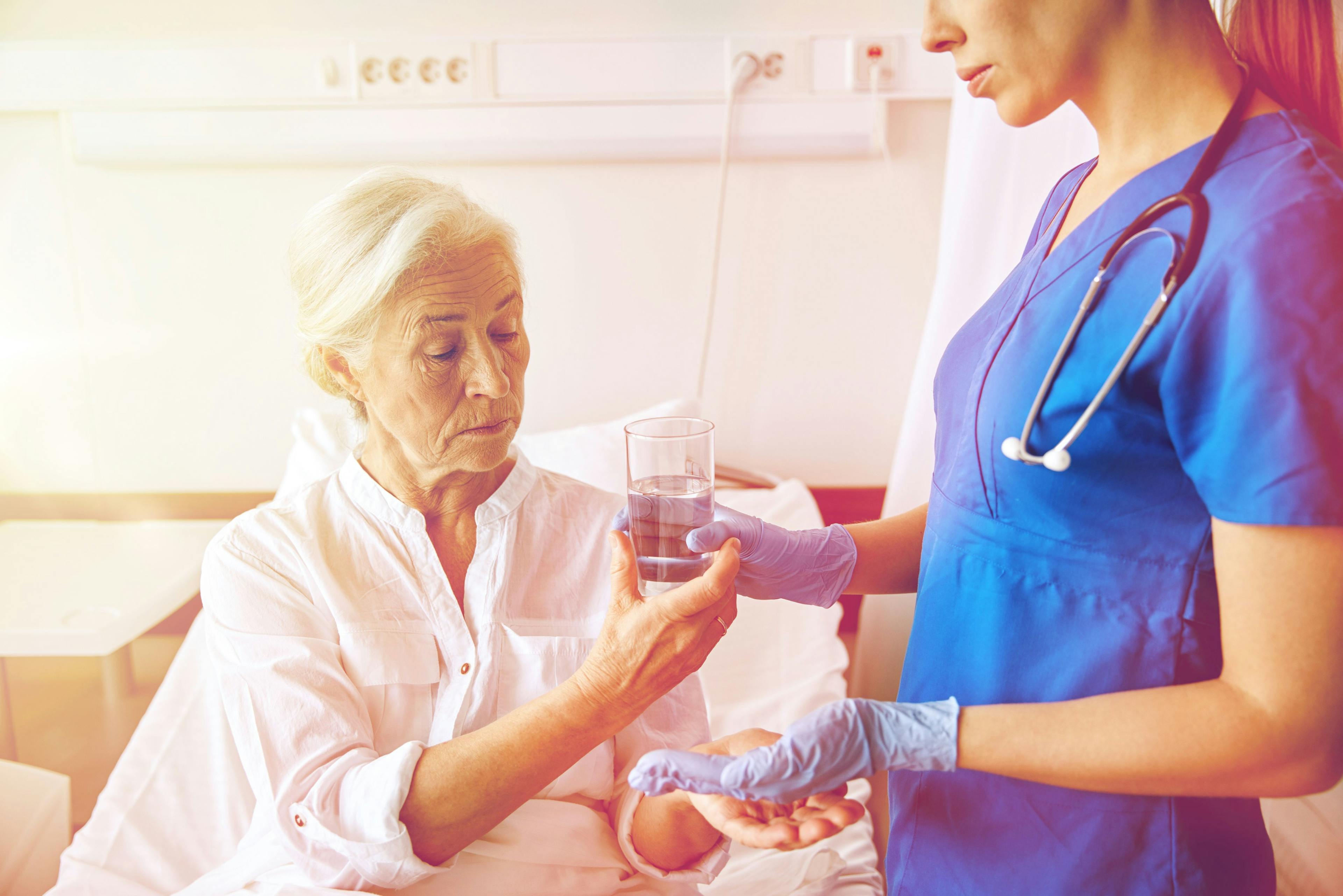 Image of a patient with cancer receiving pills from a nurse.