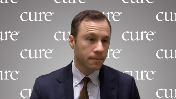 Dr. Michael Leapman in front of a gray, CURE-branded background