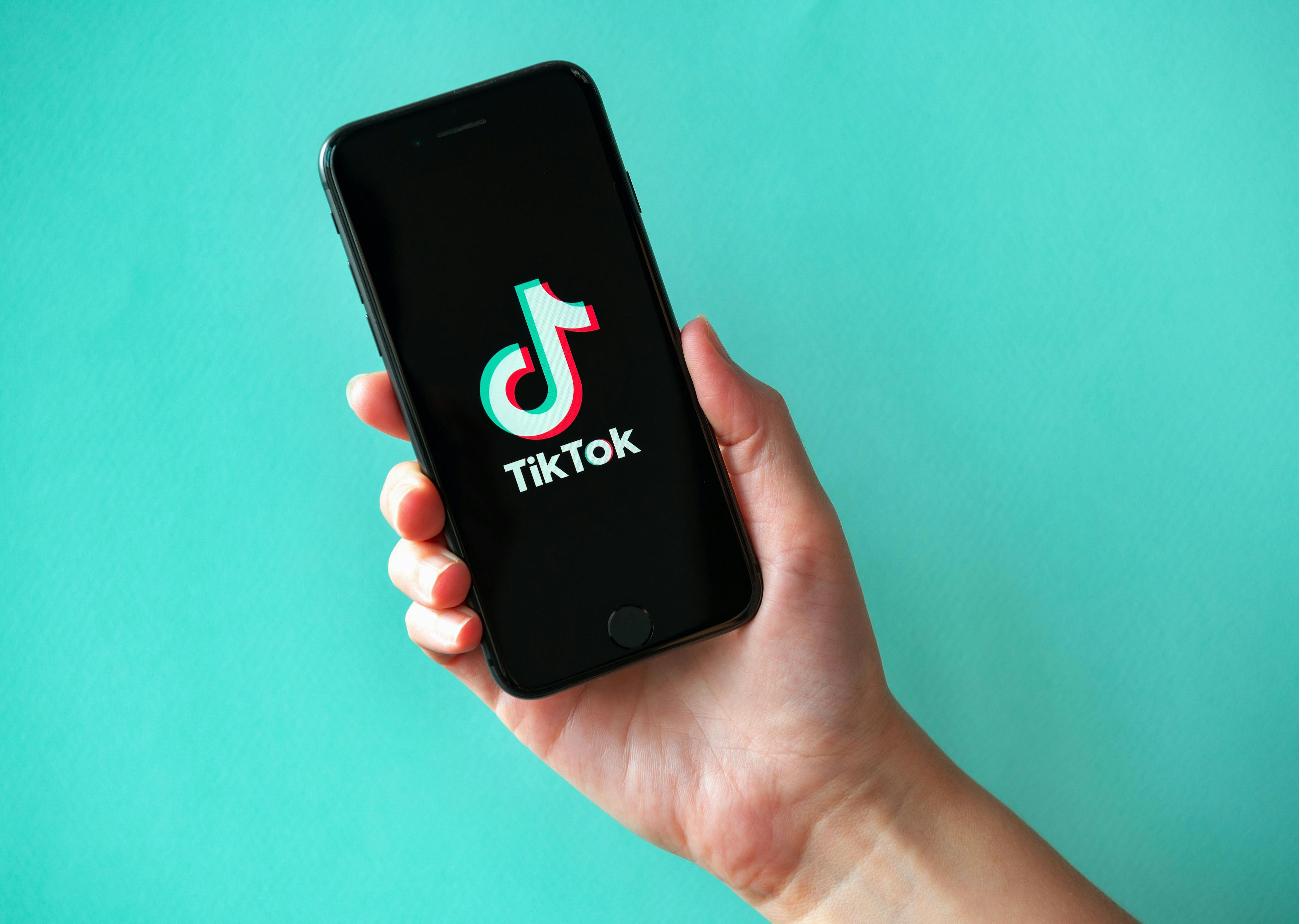 Kyiv, Ukraine - October 1, 2019: Studio shot of hand holding Apple iPhone 8 with TikTok logotype on a screen. Isolated on a vibrant cyan paper background. | Image credit: © bloomicon -  © stock.adobe.com