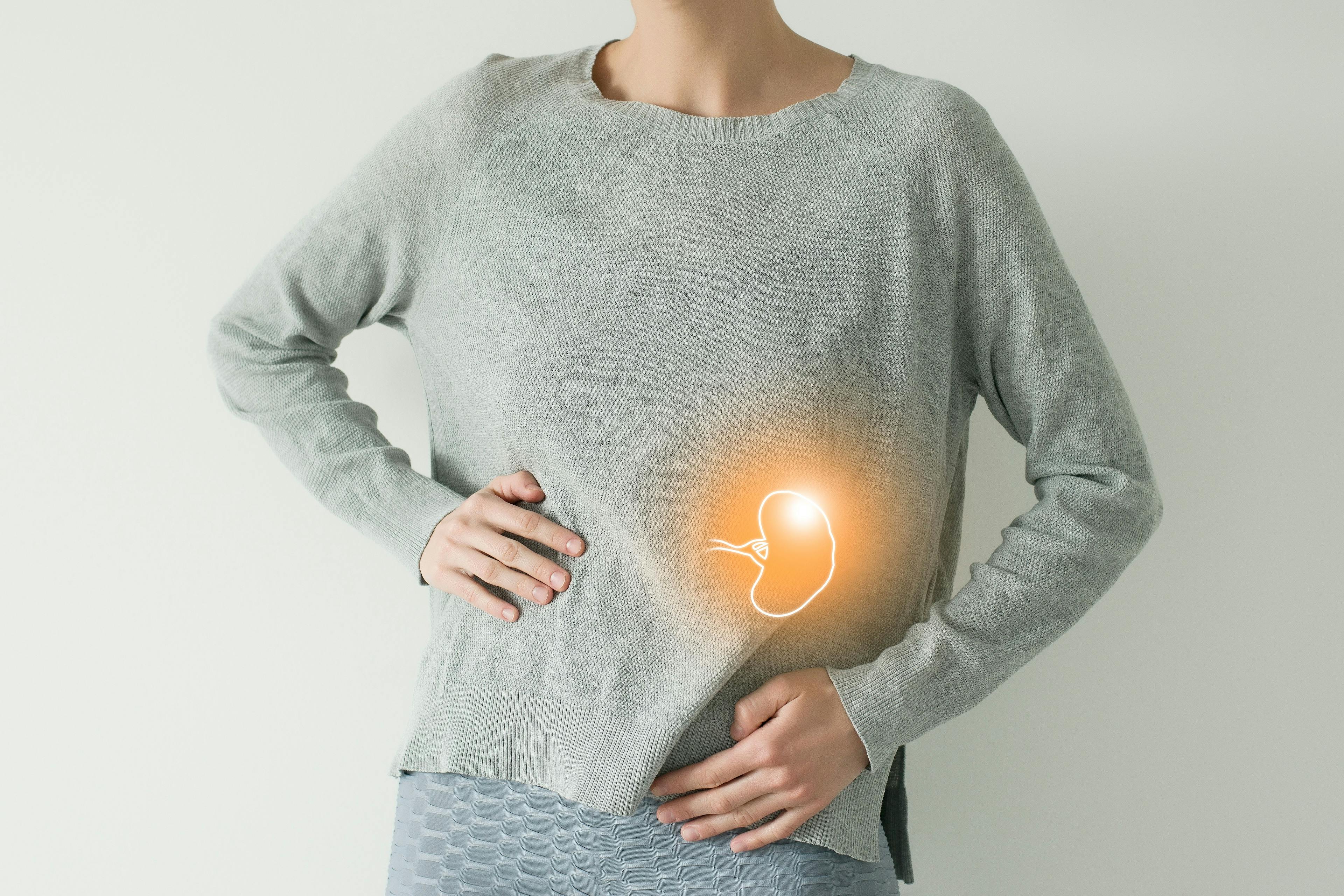 Woman in casual grey clothes suffering from indigestion pain, highlighted vector visualisation of spleen | Image credit: © transurfer - © stock.adobe.com