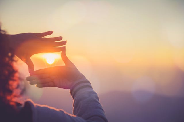 The woman making frame round the sun with her hands in sunrise,Future planning idea concept. | Image credit: ©  chartphoto - ©  stock.adobe.com