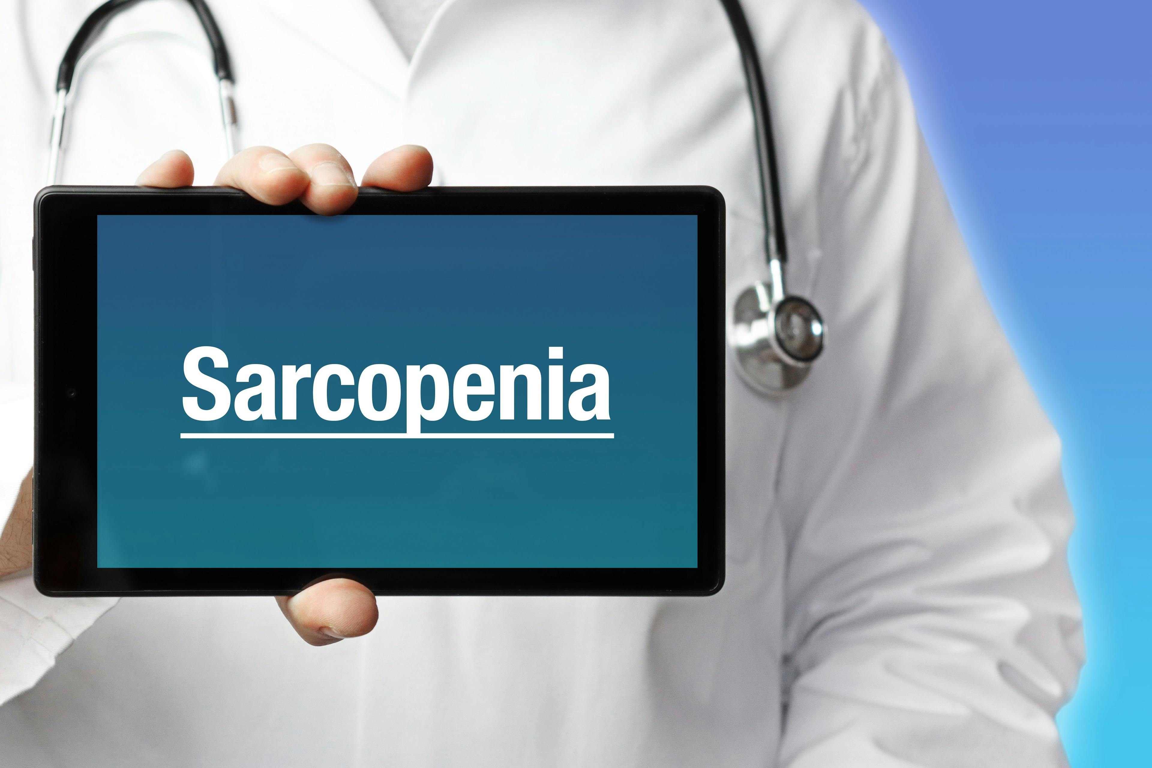 Sarcopenia. Doctor holds a tablet computer in his hand. Close up. Text is on the display. Blue Background | Image credit: © MQ-Illustrations - © stock.adobe.com