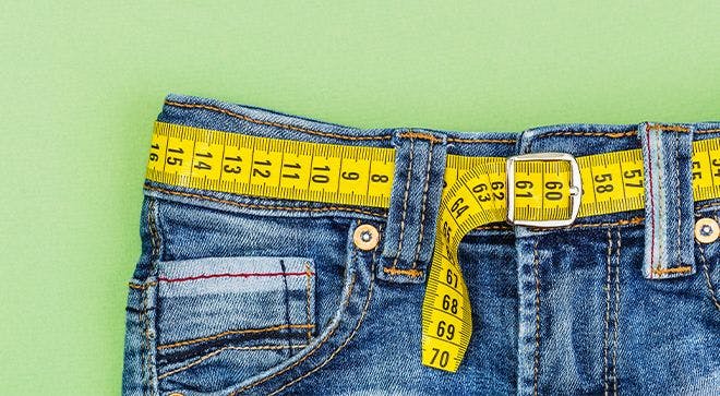 image of jeans with a measuring tape threaded through the background