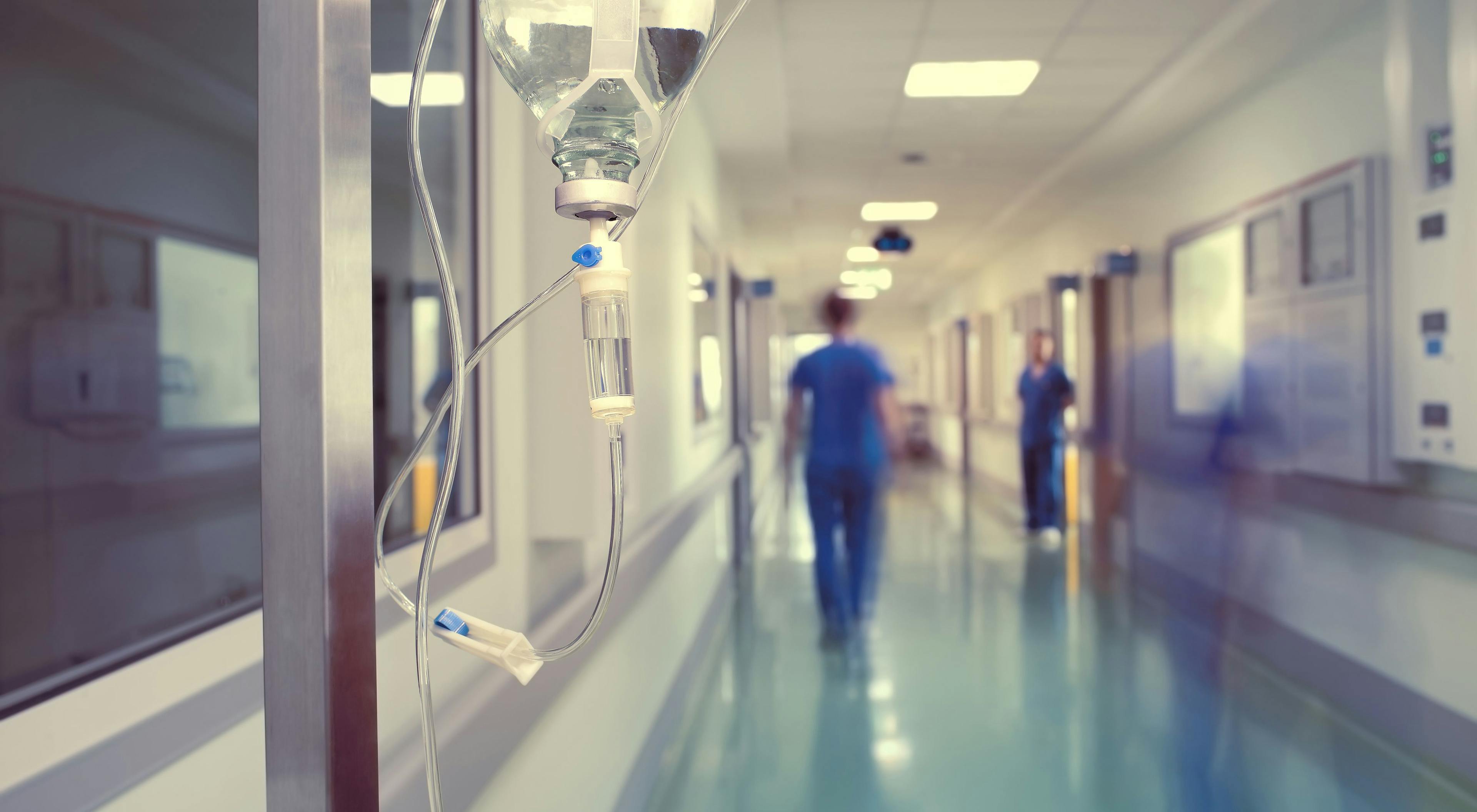 blurred hospital hallway with clinicians walking through