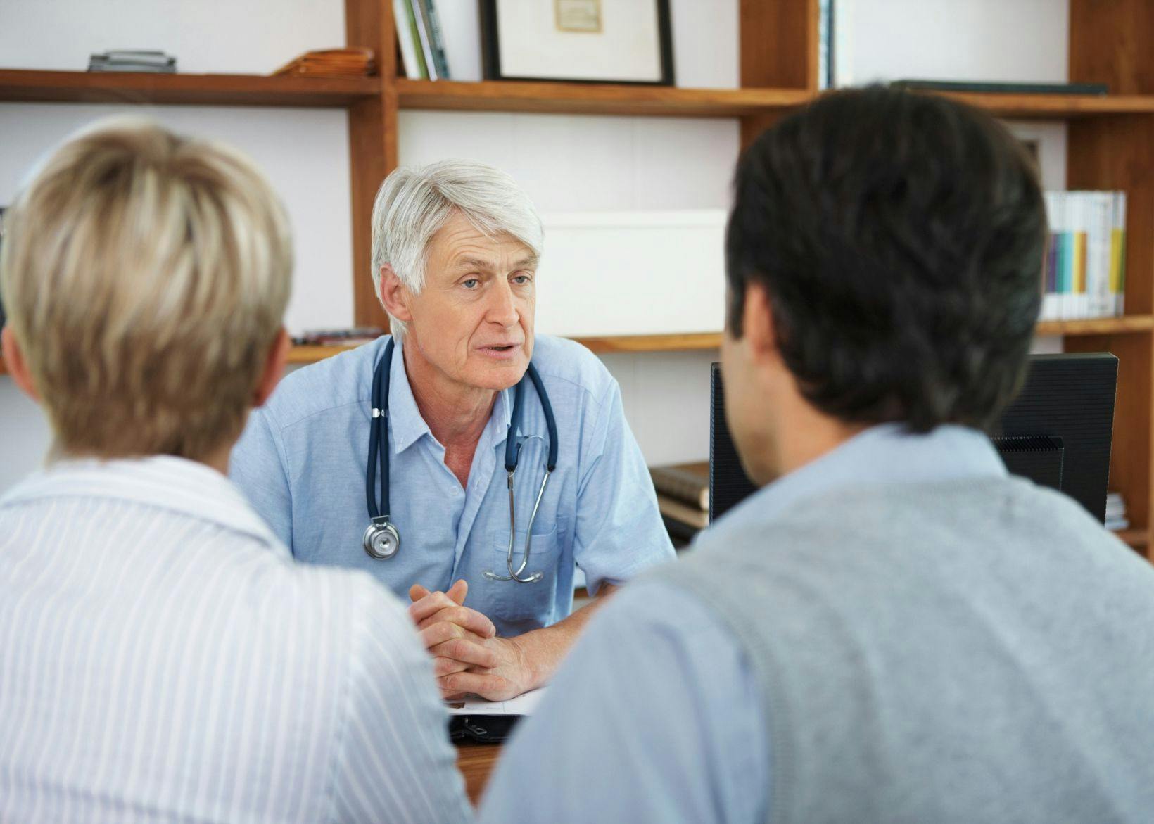 A doctor with gray hair and a blue shirt talking with patients. Opdivo and chemotherapy did not improve progression-free survival in some patients with non-small cell lung cancer.