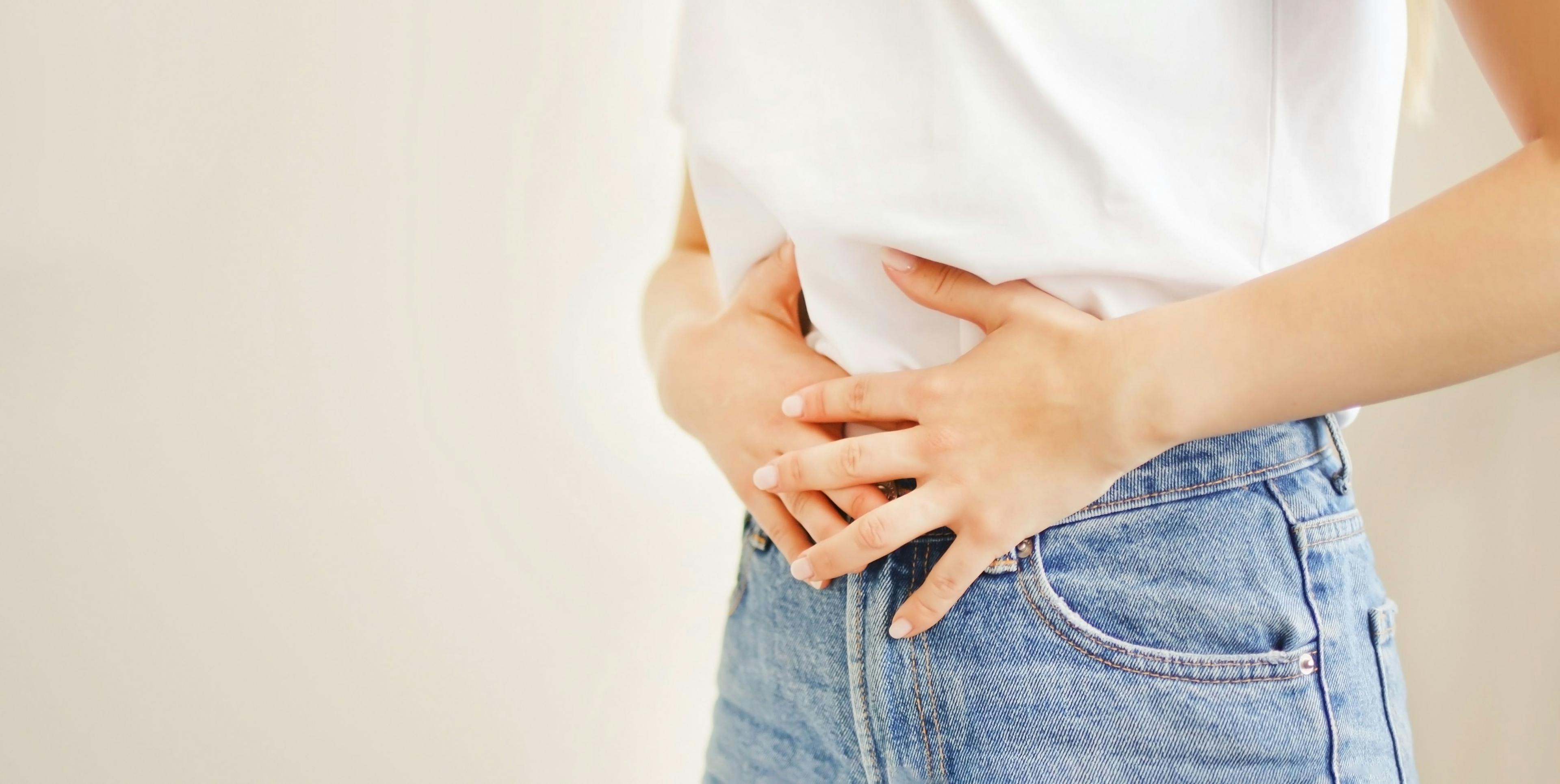 Woman suffering from stomach ache. Holding belly and feeling abdominal menstrual pain or bowel and digestion problems | Image credit: © AliceCam - © stock.adobe.com