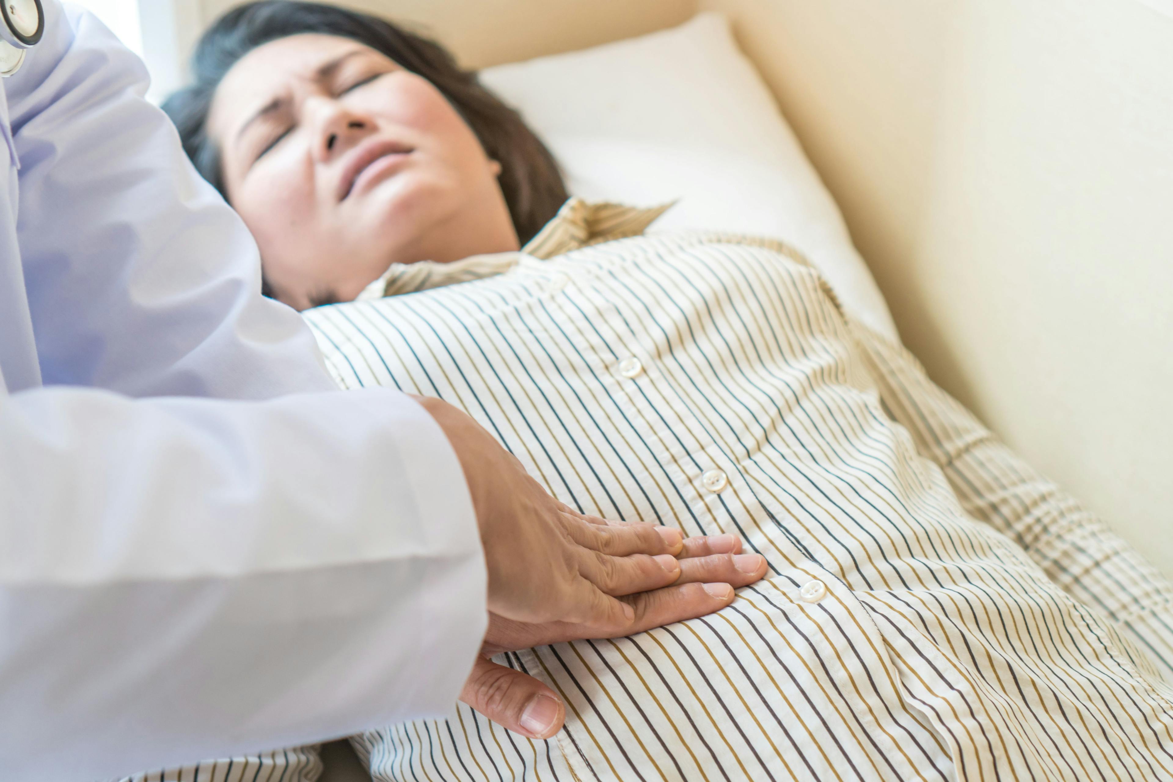 Doctor examining stomach of woman patient and pressing hands on her belly. | Image credit: ©  Pormezz - © stock.adobe.com