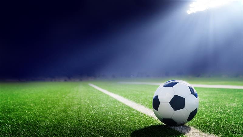 Alt text: Tradition soccer ball illuminated by stadium lights | Image credit: Mariusz Blach © - stock.adobe.com 