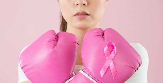 Image of a woman with pink boxing gloves and a breast cancer ribbon.