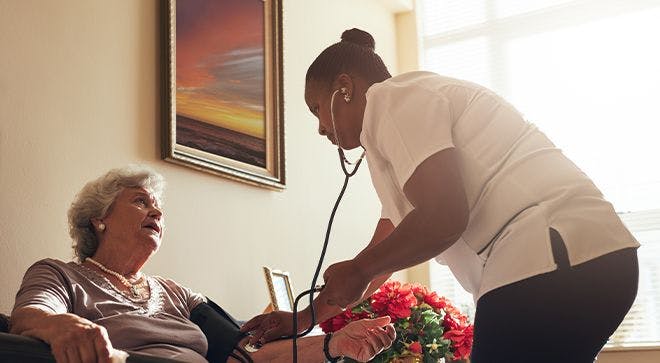 a nurse checking in on a patient. Open communication with elderly patients made them feel less demoralized.