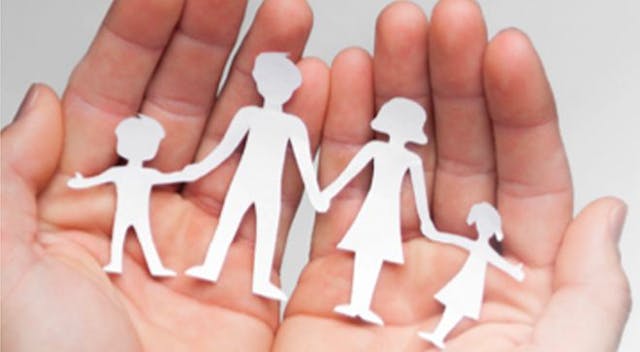 Image of a paper folded family in a person's hands.