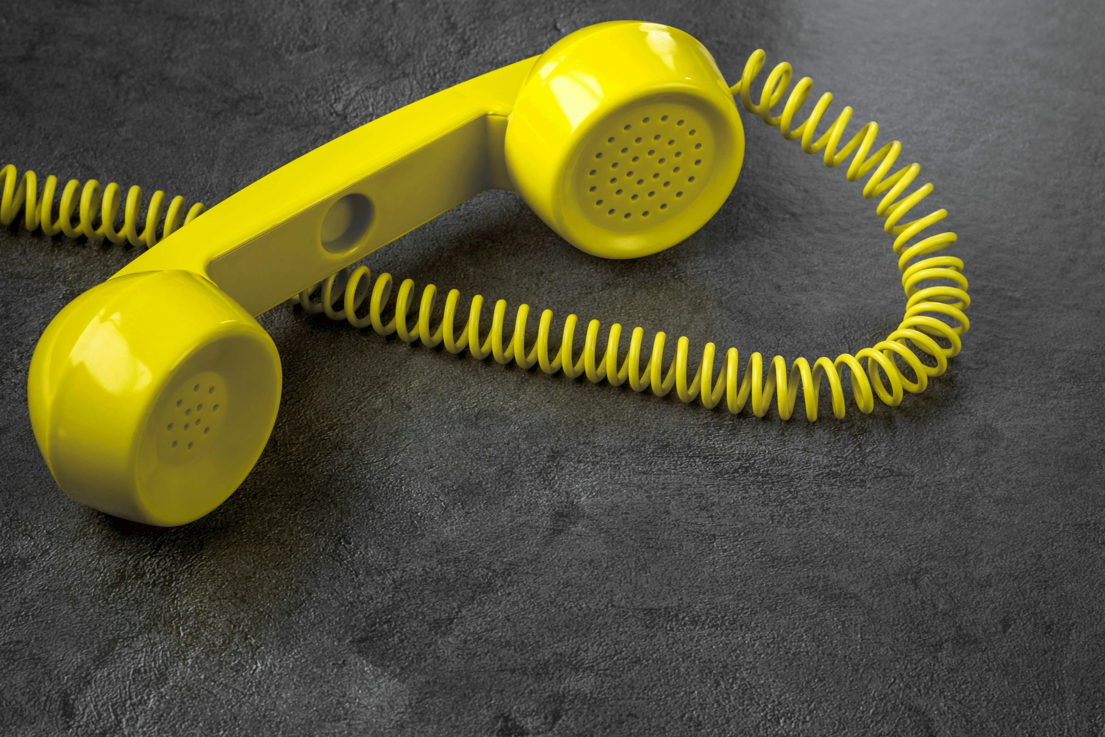 Yellow retro telephone with wire on gray marble background. Horizontal position © Aleksandr 44ARH stock.adobe.com