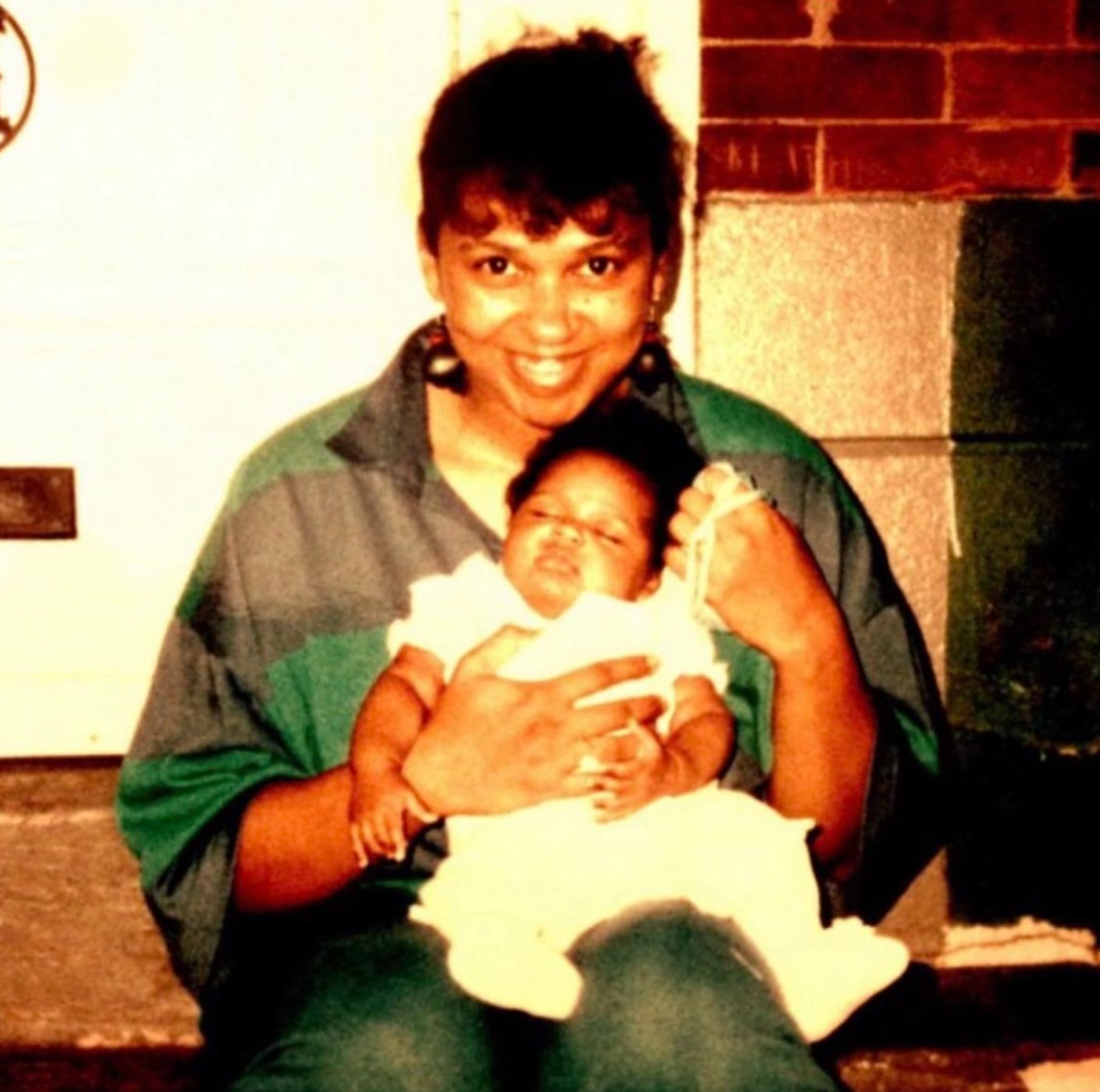 Jazmine Sullivan's mother holds her at a young age