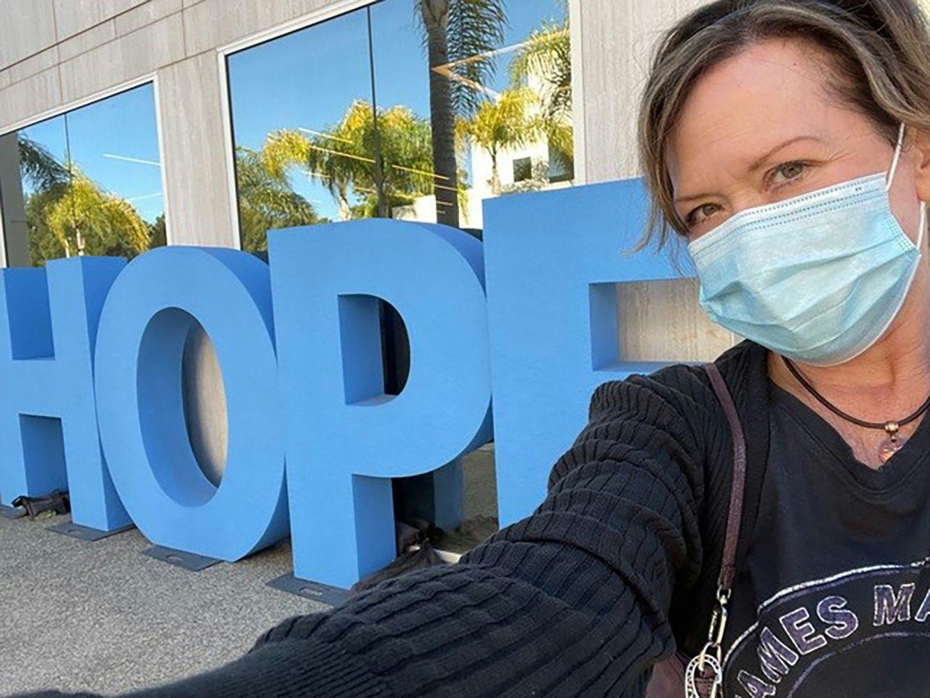 Peg Berens takes a selfie outside of City of Hope Orange County the day she received a blood draw to participate in a clinical trial to assess if there are any additional genomic mutatations driving her new progression. 
