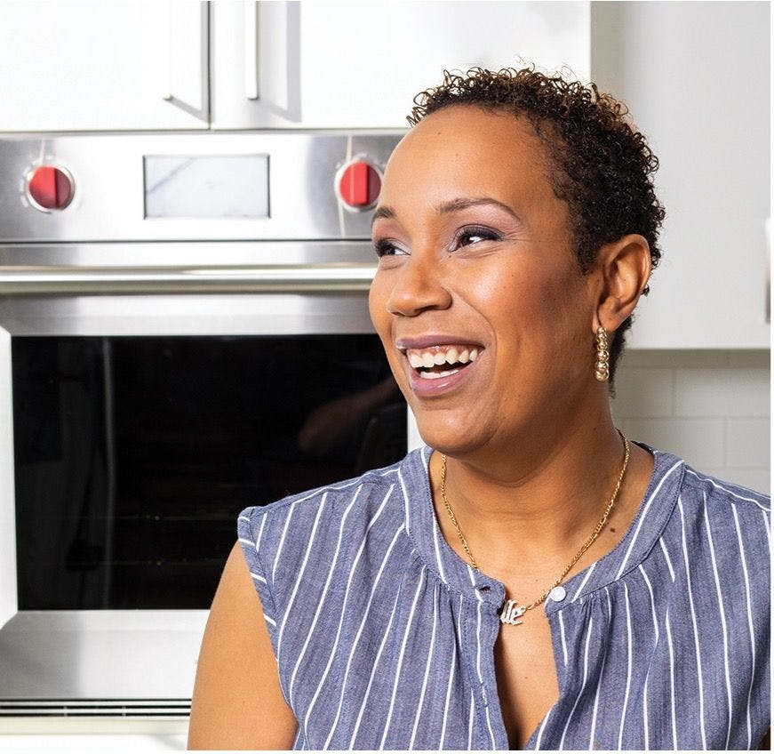 Ovarian cancer survivor Elle Simone Scott smiling in front of a stove | Photo courtesy of America's Test Kitchen
