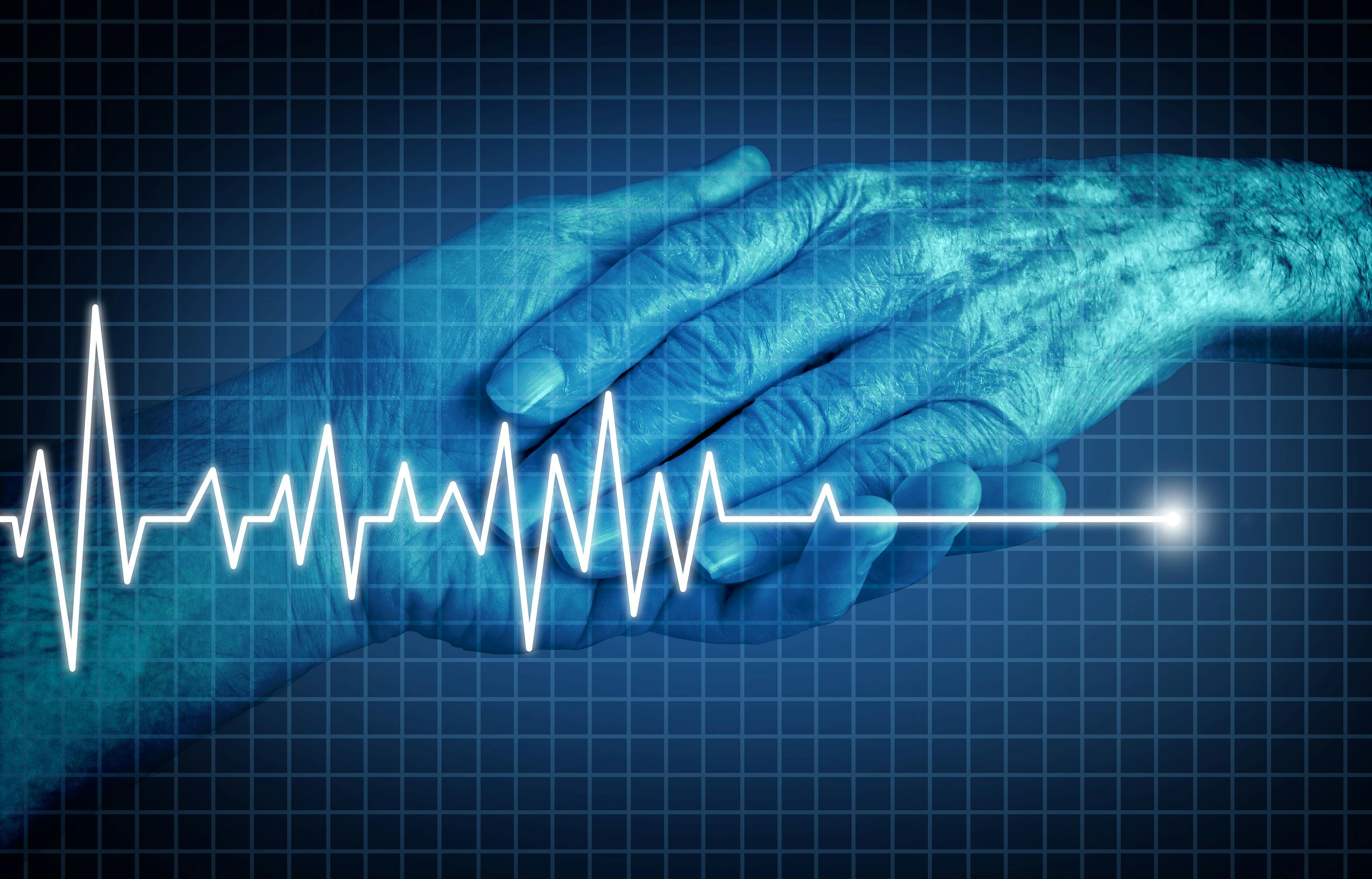 An older man's hand holding a younger man's hand. Over the image is an EKG which is spiking then flatlining