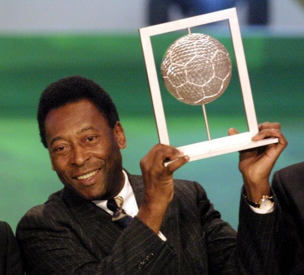 Professional soccer player, Pele, holding a soccer trophy